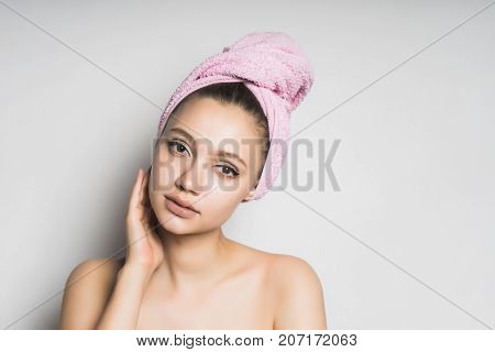 a girl with a towel tied around her head, puts on her makeup