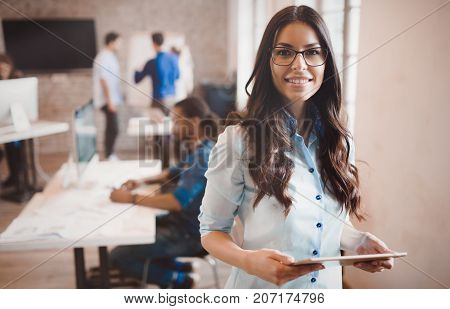 Beautiful businesswoman portrait in modern  company office holding tablet