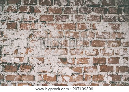 Background of old vintage dirty brick wall with plaster Brick wall background texture with faded effect Painted distressed wall surface Vintage red stonewall background