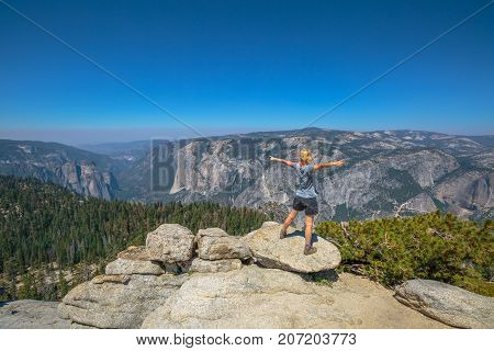 Yosemite summit panorama view for a woman after hiking in Yosemite National Park at Sentinel Dome. Aerial view of popular El Capitan from Sentinel Dome. Summer travel in United States, California.
