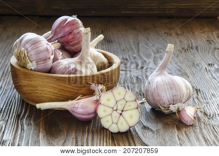 Garlic in a wooden bowl on the kitchen table