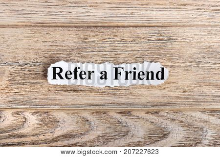 REFER A FRIEND text on paper. Word REFER A FRIEND on torn paper. Concept Image.