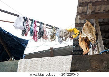 Laundry and fish drying in air on white sky background in boca de valeria brazil. Washing and fishing. Poverty household and lifestyle concept. poor life