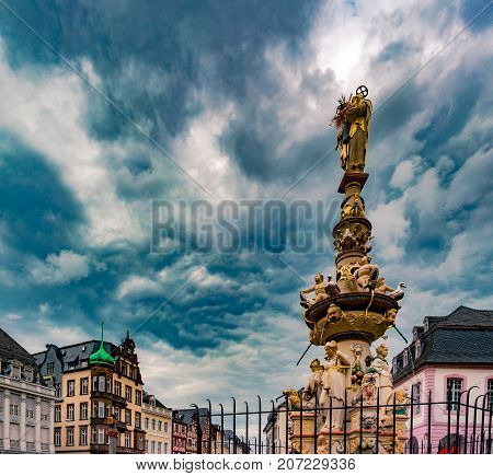 View of Hauptmarkt square in Trier, with historic fountain dating from 1595. Colorful facades in the central square Hauptmarkt with the monuments Petrusbrunnen and Market Cross