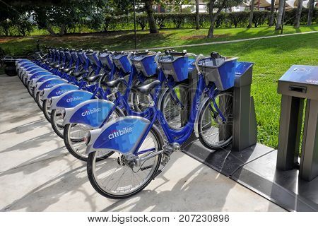 Miami USA - January 05 2016: citibike blue bicycles for rental on station on green grass background. Bike sharing dock. Summer vacation and travelling. Active and healthy lifestyle concept. ecology