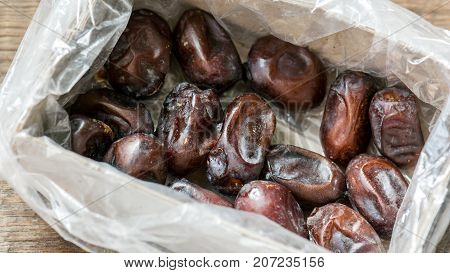 Fresh sweet dates in box on wooden background, close up