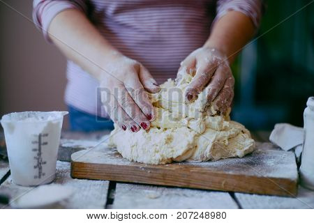 Close Up View Of Baker Kneading Dough. Homemade Bread. Hands Preparing Bread Dough On Wooden Table.