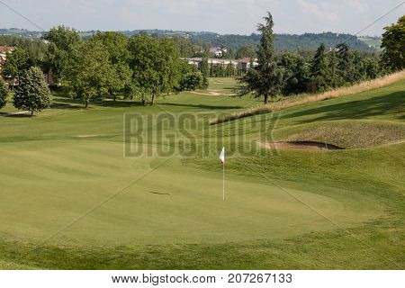 White Flagstick in Green Golf Course in Sunny Day