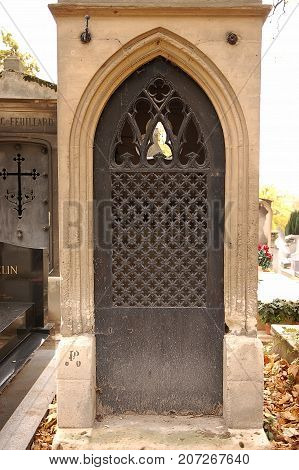 Old ornate iron door. Entrance to an old tomb crypt at a cemetery.