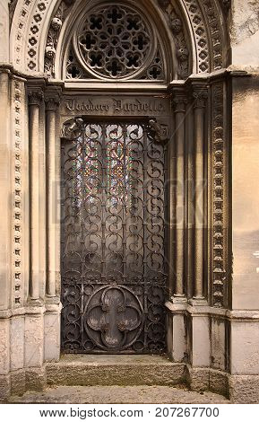 Old ornate iron door. Entrance to an old tomb crypt at a cemetery.