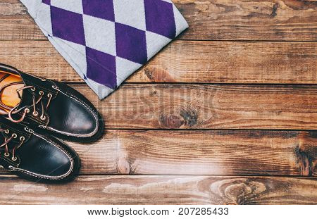 Dark brown top-siders and sweater on the wooden rustic background