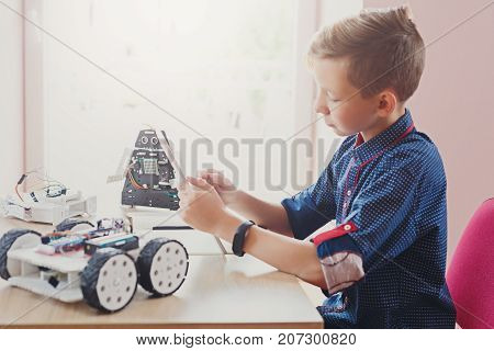 Stem education. Concentrated boy creating robot at lab. Early development, diy, innovation, modern technology concept