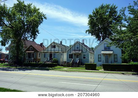 JOLIET, ILLINOIS / UNITED STATES - JULY 25, 2017: A row of small Cape Cod style houses, built very close together, on Broadway Street, in one of Joliet's less affluent neighborhoods.