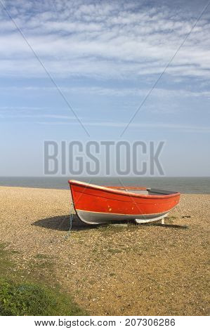 Red fishing boat on Dunwich Beach in Suffolk England