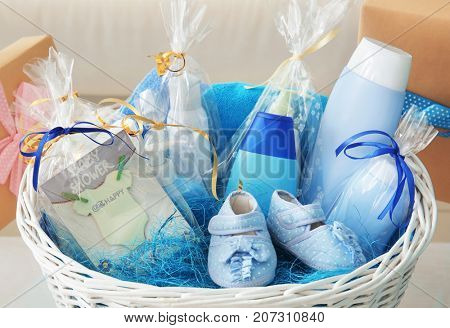 Wicker basket with baby shower gifts indoors