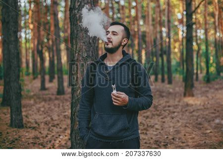 The Model Vaper Vaping A Vaporizer Outdoors. Safe Smoking. Young Vaper.
