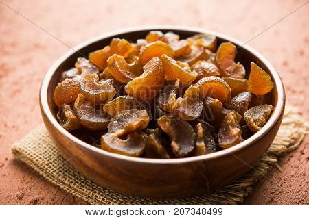 Ayurvedic Amla Candy, which is dried and salty-sweet or chatpata in taste and digestive. Served in a wooden bowl, selective focus