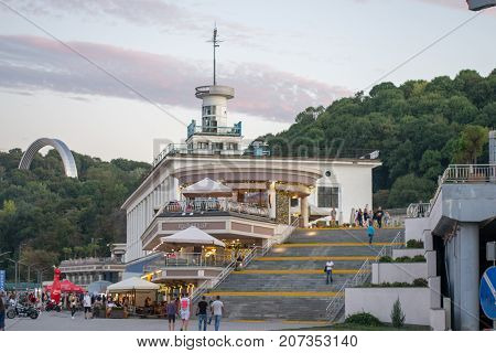 UKRAINEKIEV-SEPTEMBER 242017: Restaurant Kompot and people walking down staircase leading to the park on Naberezhnaya street in evening.