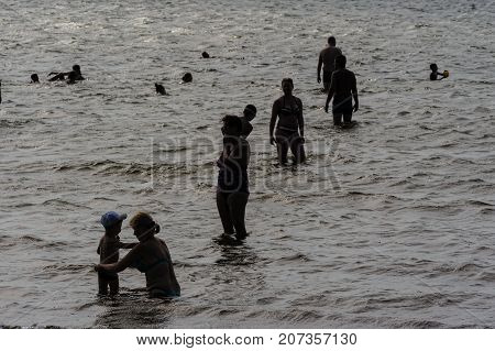 Group Of People In Sea. Silhouettes