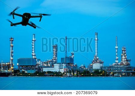 Modern RC Drone / Quadcopter with camera flying on Oil refinery plant site. double exposure