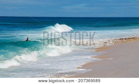 Boogie Board Rider, surfing waves on blue sea at white sandy beach on Island of Ohau, Hawaii
