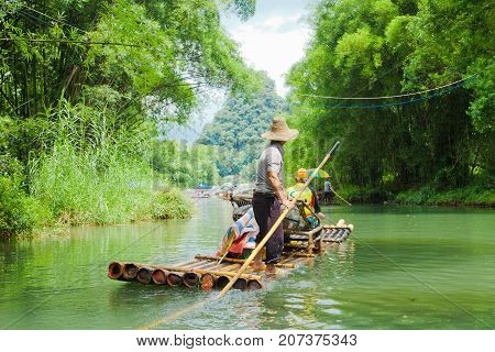 yulong river china July 2011: In July tourists travel on these bamboo rafts on the yulong river to admire the karst peaks covered with dense vegetation during an exciting water tour