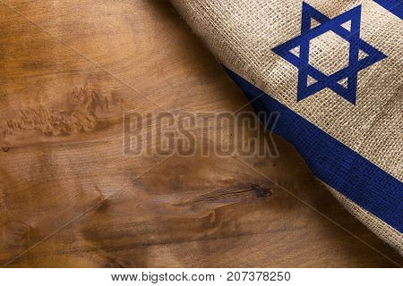 Flag of the State of Israel from rough fabric on a wooden surface