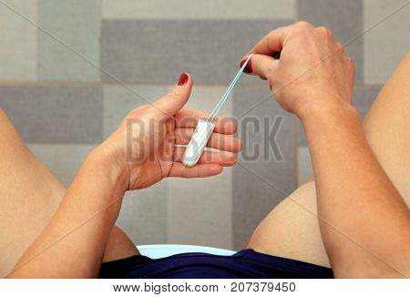 tampon in hand of woman for use at periods