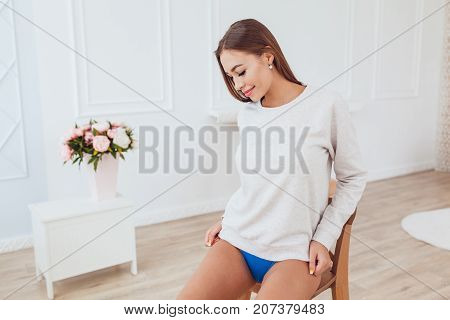 Sexy girl in a gray sweatshirt and panties. Mock-up.