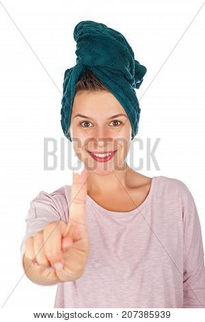Smiling young woman with bathtowel on head and moisturizing cream on her finger on isolated