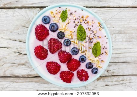 A bowl of healthy and delicious smoothie with grains and fresh berry fruit.