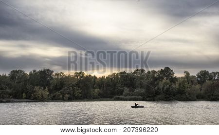 Man in the boat is fishing water sky