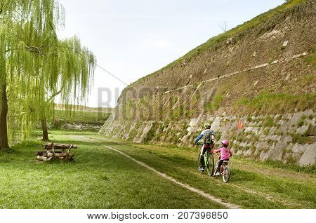 Family cyclo holidays across town of Palmanova and its defense walls and trenches, Friuli Venezia Giulia region of Italy. Family, education, recreation and sport concept.