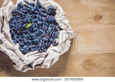 Fresh Honeysuckle Blue Berry Fruits With Leaf On A Wooden Background
