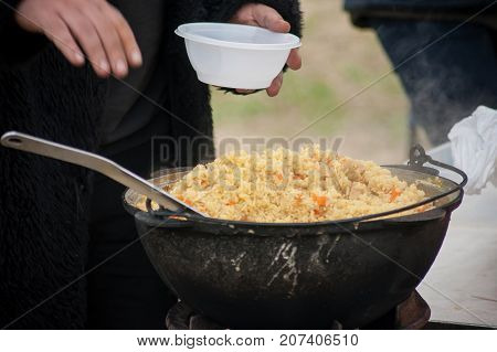 pilaf in a big cauldron cooked outdoors
