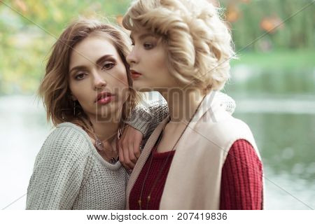 Young beautiful women near lake. Glamour fashion portrait.
