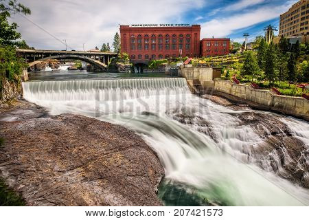 SPOKANE, WASHINGTON, USA - JULY 4, 2017 : Falls and the Washington Water Power building along the Spokane river in Spokane, Washington.