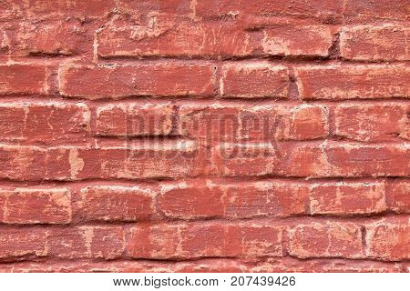 An old brick masonry wall of a warehouse made of red brick.