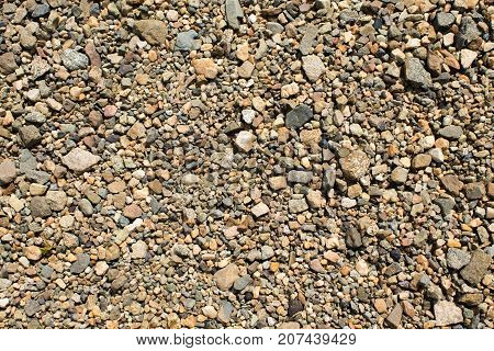 Fine gravel of warm color texture of road stone of fine fraction.