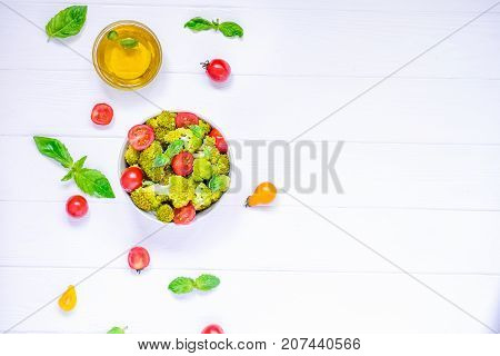 Top View Salad Bowl With Cherry Tomatoes, Boiled Broccoli, Basil And Fresh Ingredients On The White