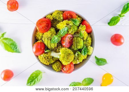 Top View Salad Bowl With Cherry Tomatoes, Boiled Broccoli, Basil And Fresh Ingredients On The White