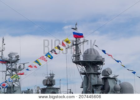 Top part of big military battleship with towers masts flags of coloring and antennas