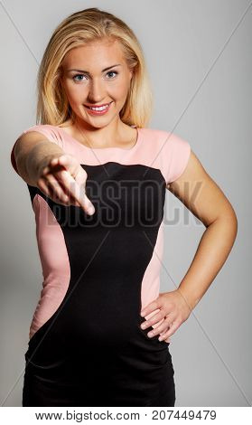 Young woman showing finger, pointing on you.