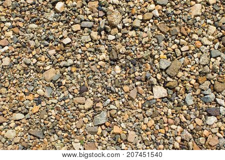 Fine gravel of warm color texture of road stone of fine fraction.