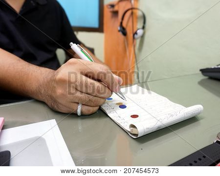 Close up hands of man work as a car paint mixing technician was to examine accounts.