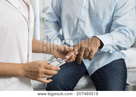 Female Doctor Examining Patient's Sugar Level With Glucometer