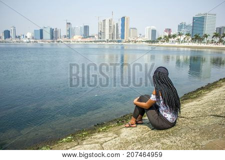 A young girl watching the Luanda city