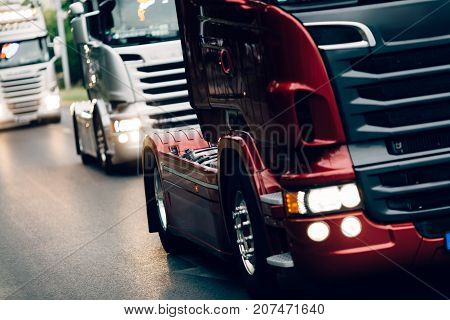 Trucks being driven on road picking up goods