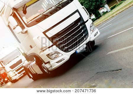 Trucks being driven on road picking up goods