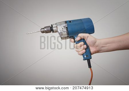 A man's hand with an electric power drill. Mechanic Service Maintenance Concept